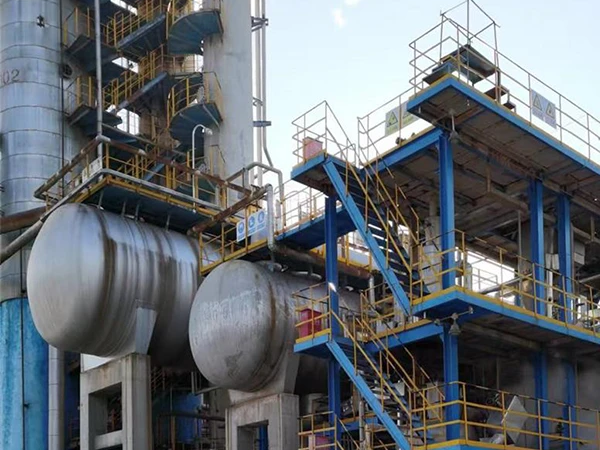 Catalyst filtration with silver tanks, blue-yellow railings, and a plastic-wrapped tank