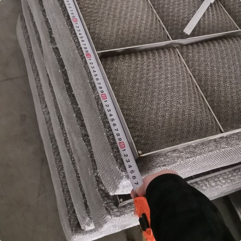 A worker is measuring the length of demister pad.