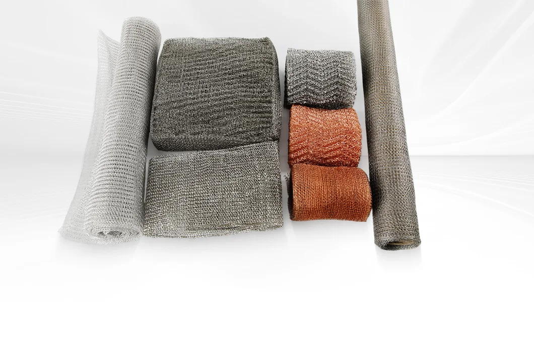 Various knitted wire meshes (metal, different colors/shapes: rolls, blocks) on a white background.