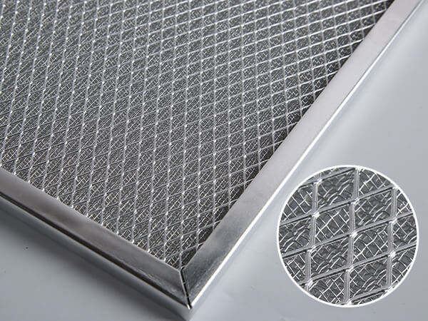 A corner of a piece of metal mesh air filter on a desktop