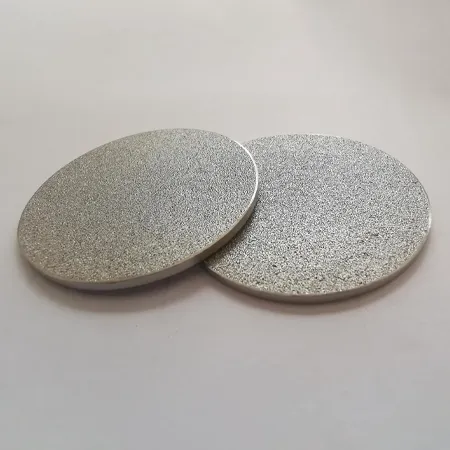 Two circular, sheet-like sintered porous discs on a gray background
